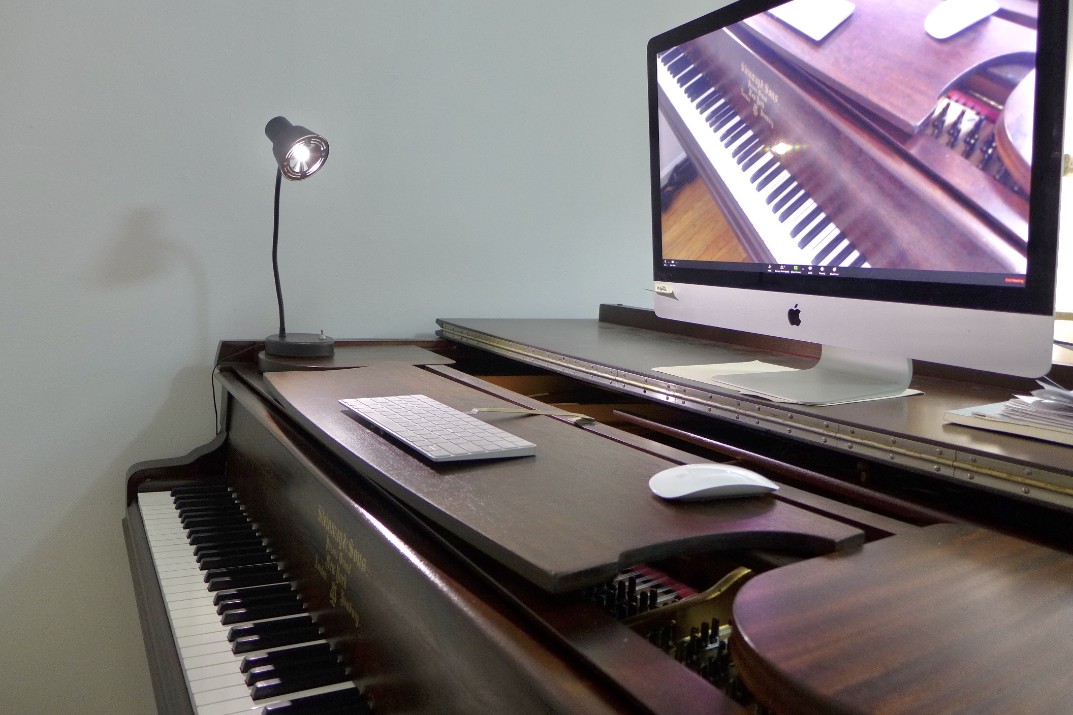 image of steinway grand piano with 27inch iMac placed on the lid to conduct online lesson.